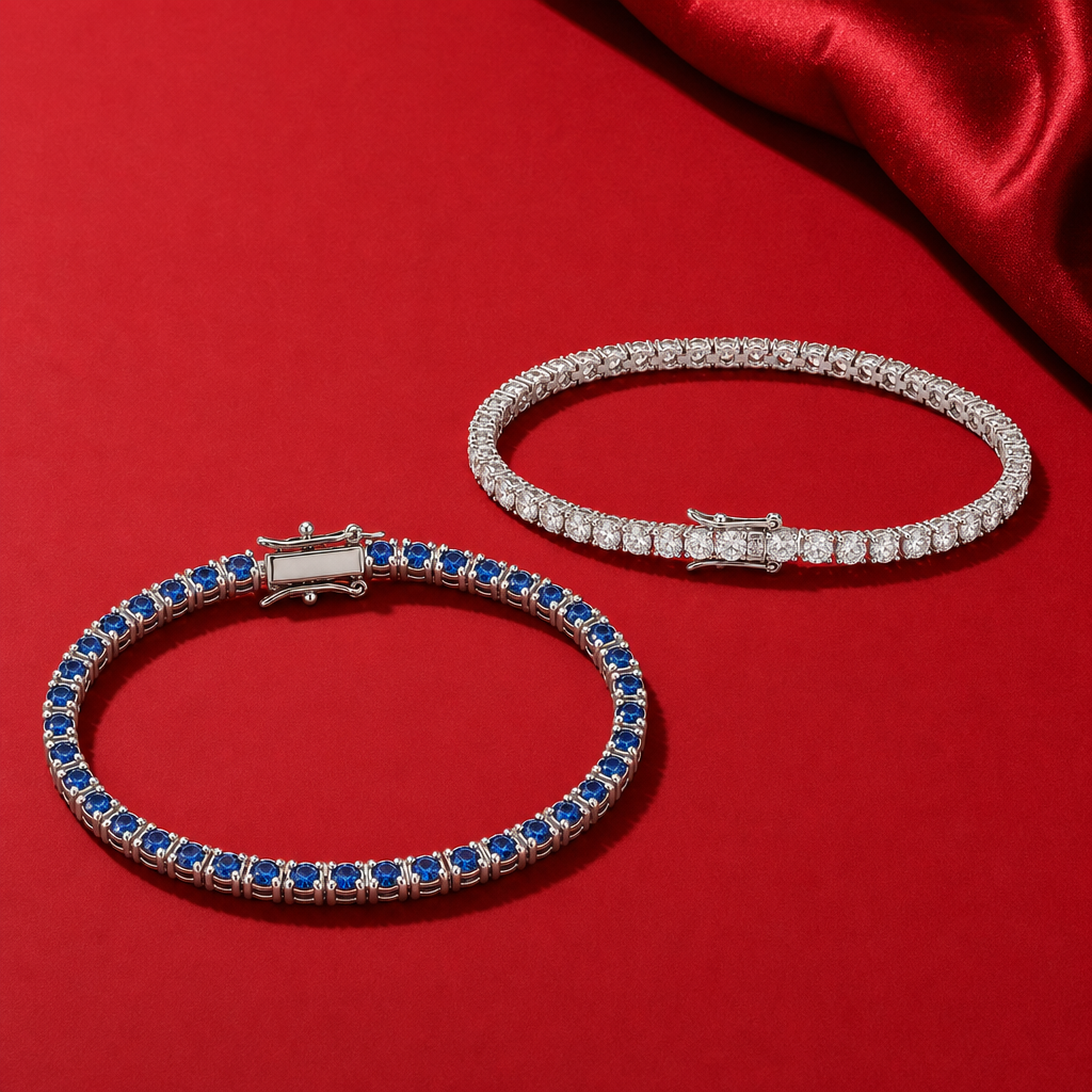 Deux bracelets tennis de couleur argentée, avec pierres transparentes et bleues, sur fond rouge.