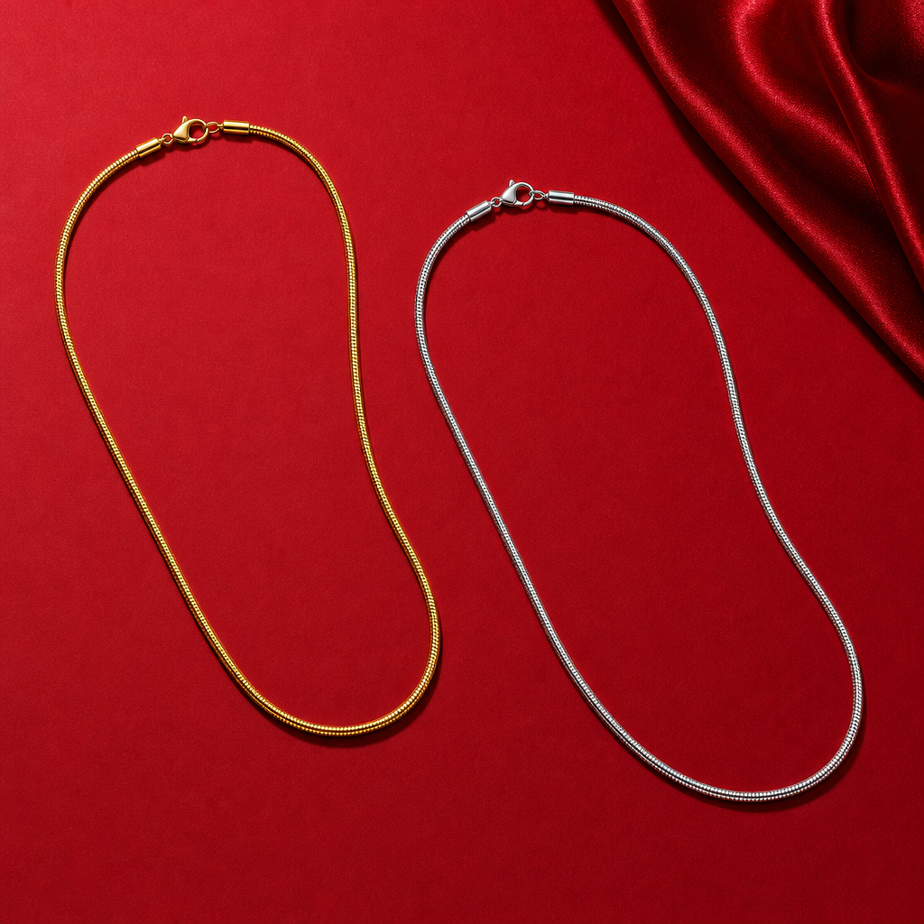 Deux chaînes serpent fines, de couleur dorée et argentée, sur un fond rouge.