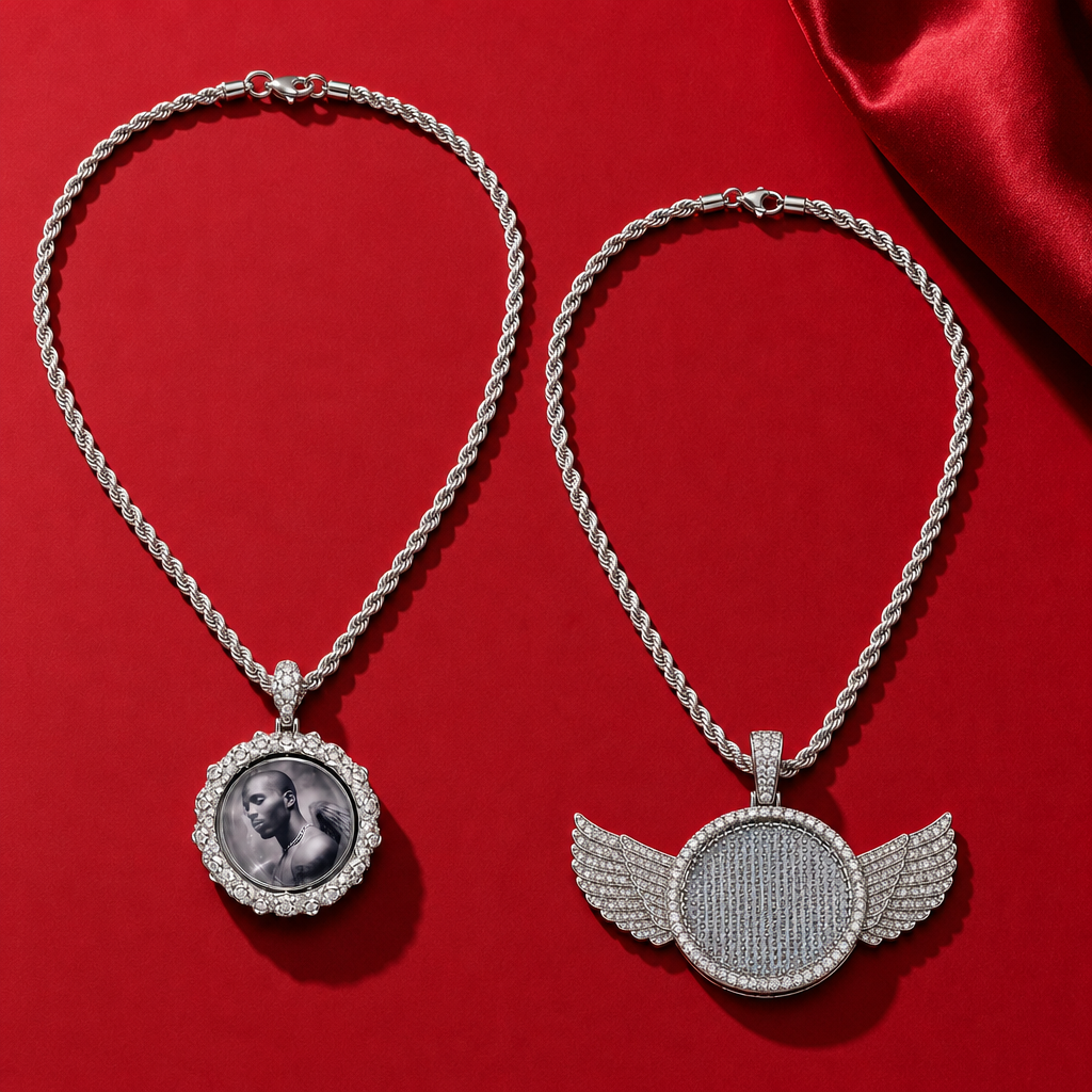 Deux colliers à pendentif photo rond, dont un modèle entouré d’ailes, sur un fond rouge.