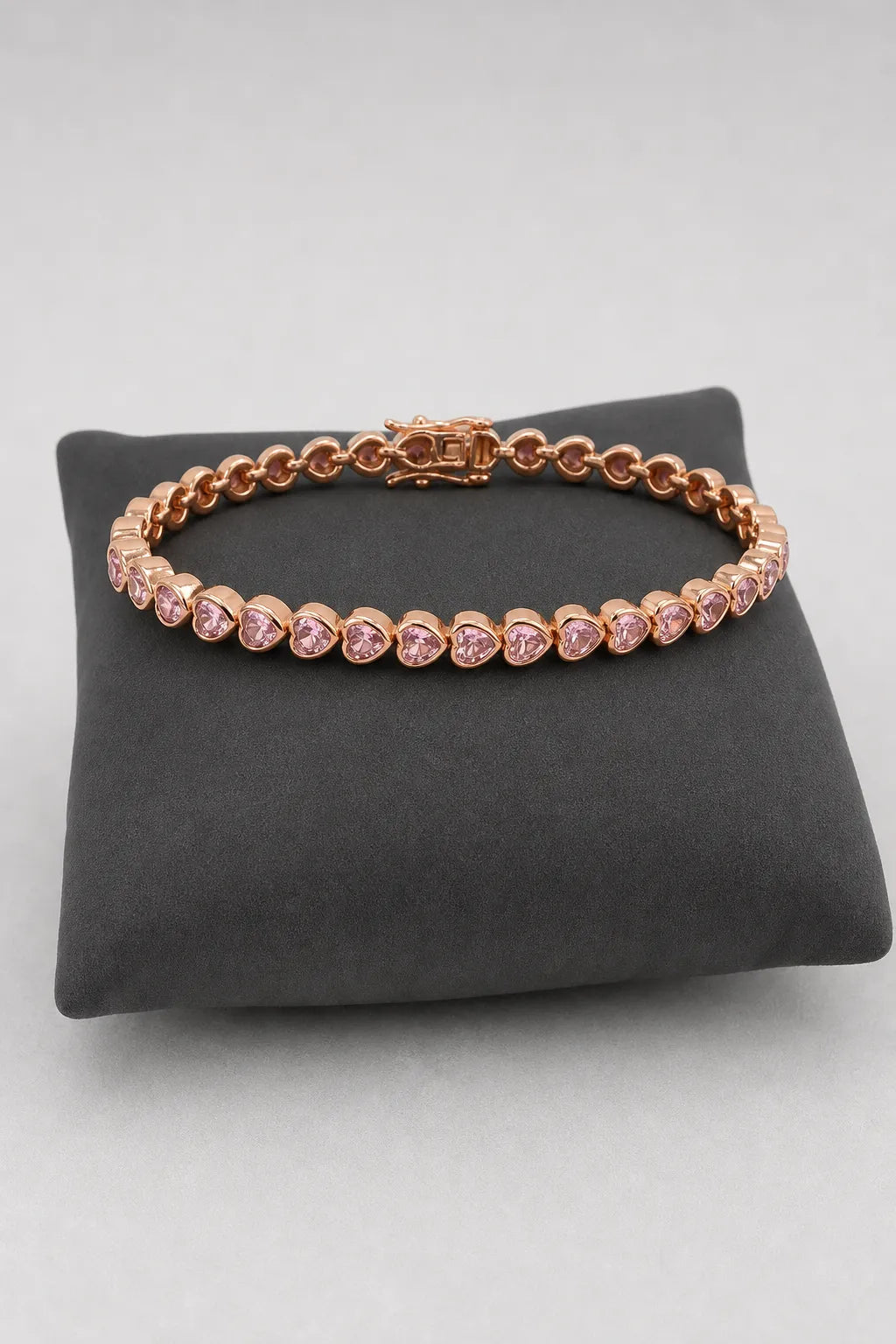 Heart Bezel Tennis Bracelet — Rose-gold-tone with clear/pink heart stones — on a display cushion