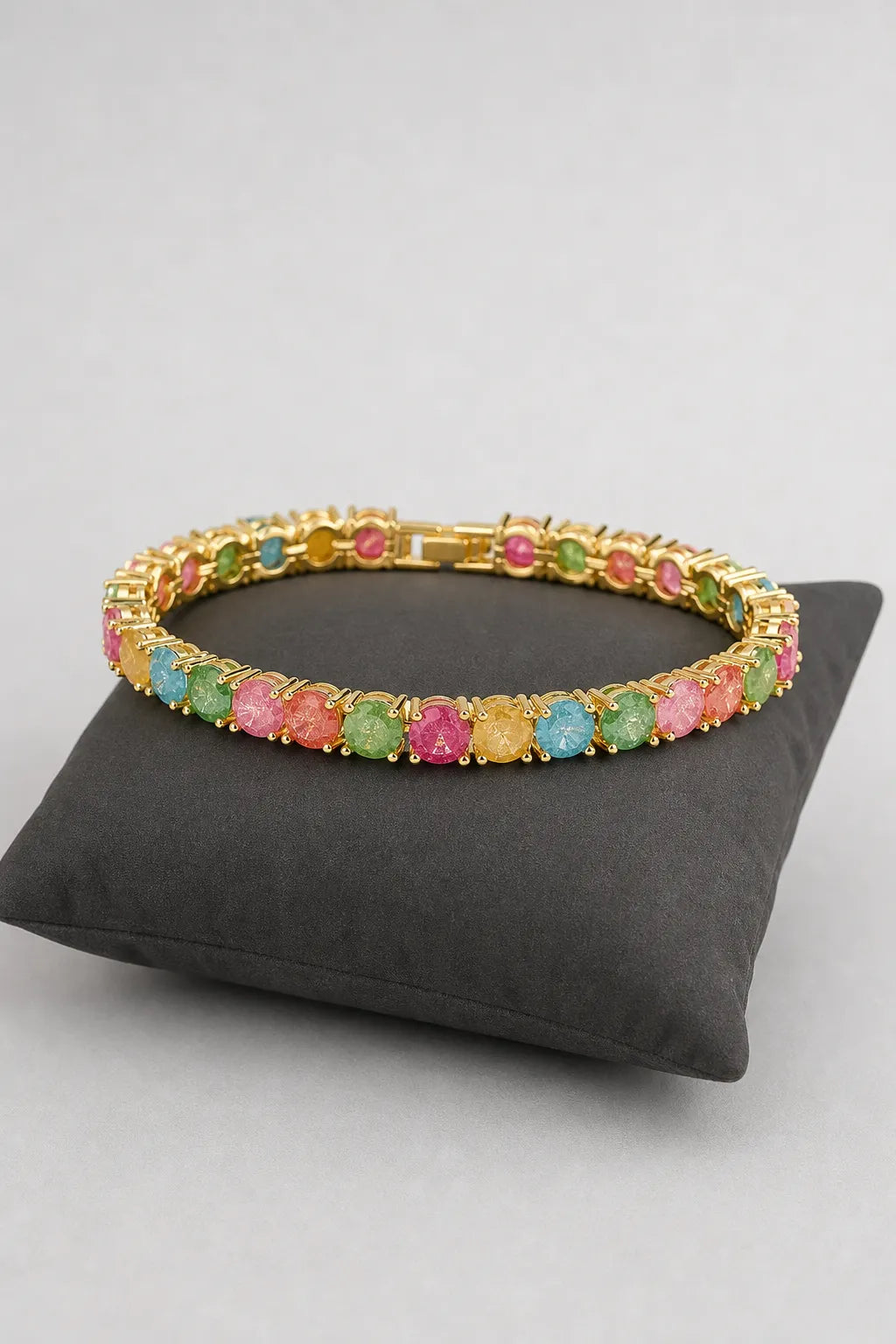 Multicolor Tennis Bracelet — Gold-tone multicolour bracelet — on a display cushion