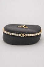 Personalized Tennis Bracelet — Gold-tone with clear stones, DR example — on a display cushion