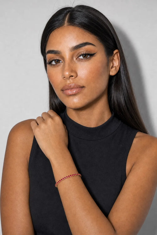 Red Tennis Bracelet — Red stones — gold-tone metal — worn on an adult wrist